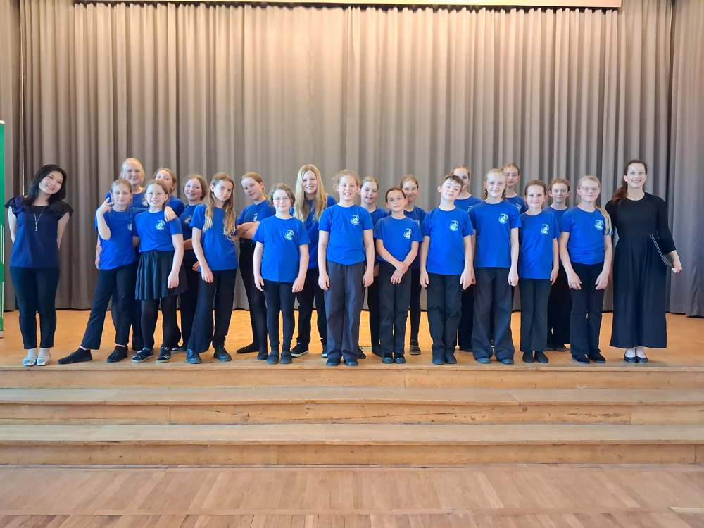 Der Kinderchor in blauen Chor-Shirts auf der Bühne